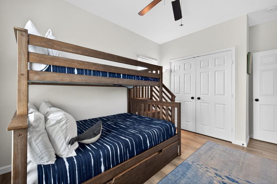 Cozy bunk room with ceiling fan for shared family stays.