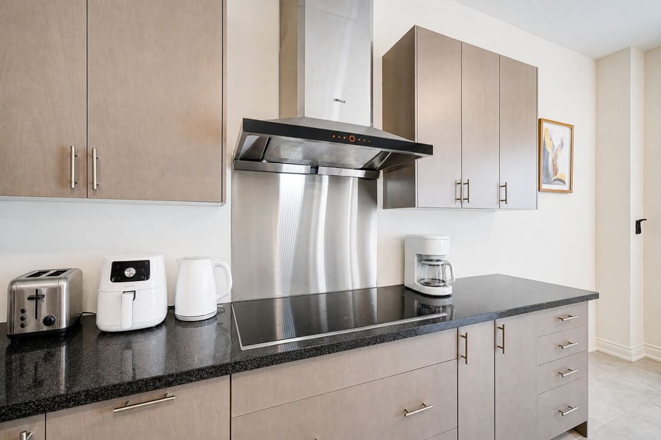Modern kitchen with sleek finishes, coffee maker, and handy cooking essentials