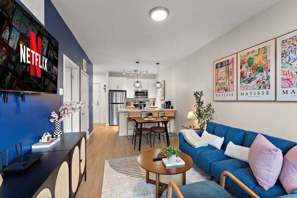 Modern living space with a Smart TV, comfortable sofa, colorful artwork, and an inviting setup for relaxing after a day out.