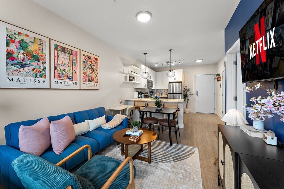 Open-concept living and dining area with modern decor, comfortable seating, and a welcoming city-stay vibe.