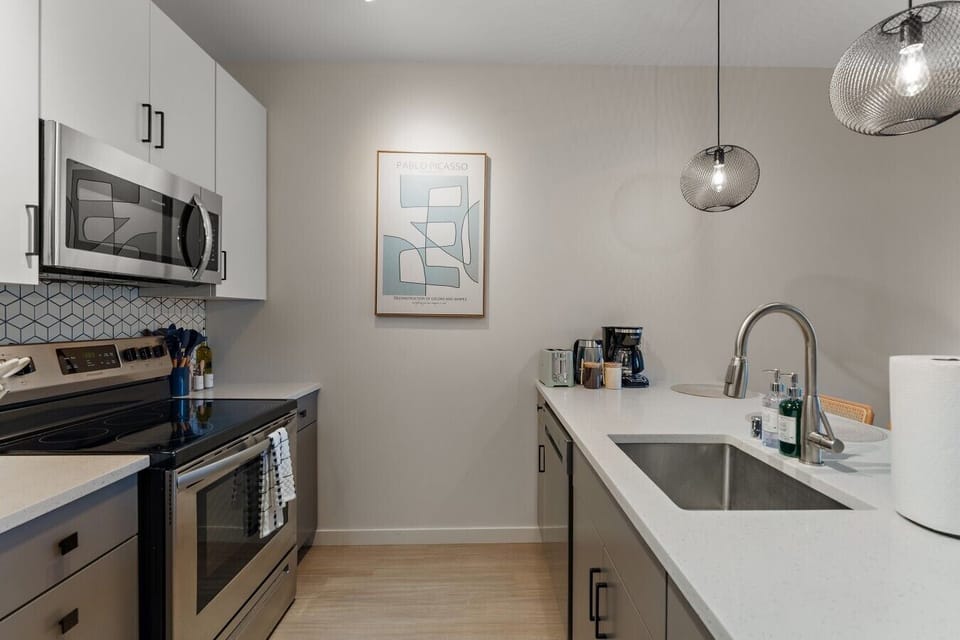Modern fully equipped kitchen with sleek appliances, spacious countertops, coffee essentials, and everything needed for a comfortable stay.