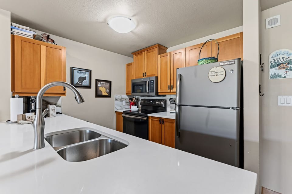 Your fully equipped kitchen features stainless steel appliances, a microwave, and a spacious double sink, perfect for preparing meals during your stay.