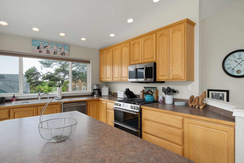 A fully equipped kitchen awaits you with modern appliances, ample counter space, and natural light streaming through large windows overlooking scenic surroundings—perfect for preparing your favorite meals.