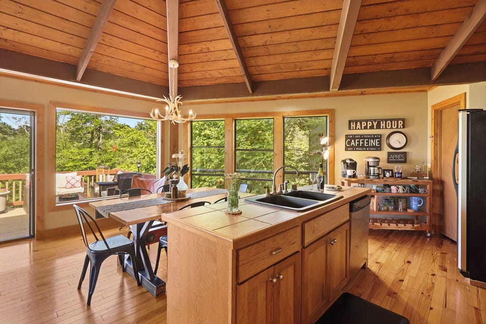 The sunny open kitchen and dining space at Beech Mountain Place is bright and inviting — soaring vaulted wood ceilings and abundant natural light create a warm atmosphere perfect for cooking and gathering together.