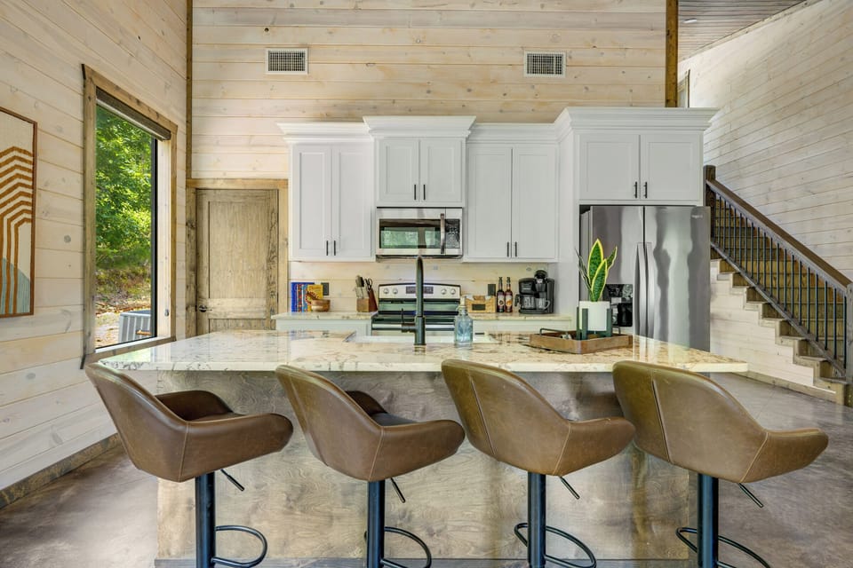 Bright gourmet kitchen with waterfall island and soaring wood ceilings