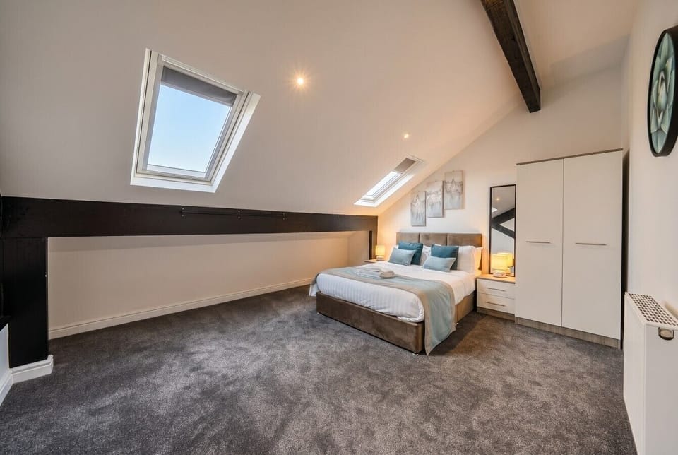 Light-filled loft bedroom with skylights and original beams for restful nights