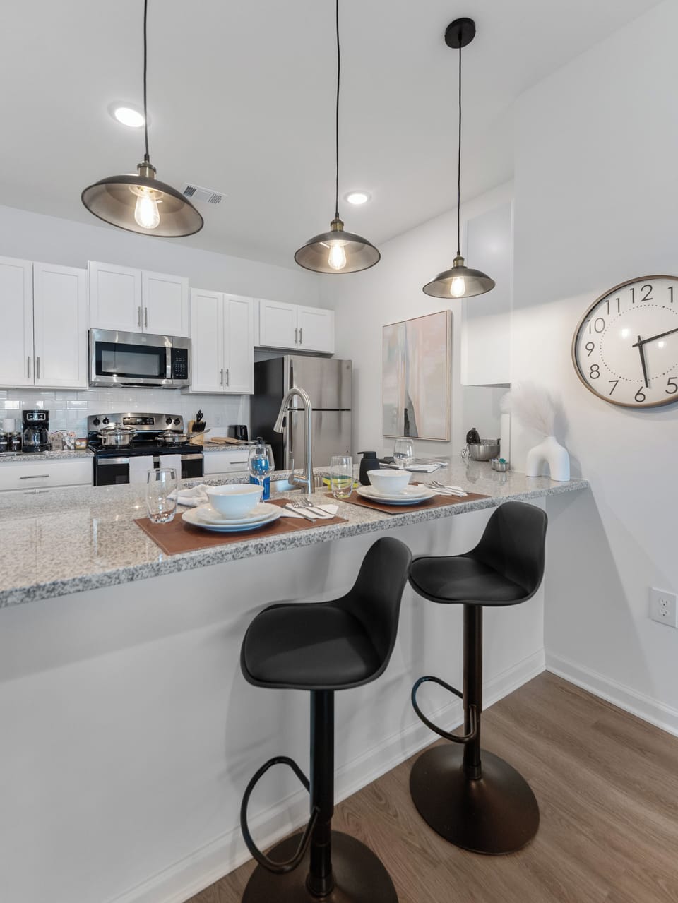 Modern kitchen with granite counters, stainless appliances & barstool seating
