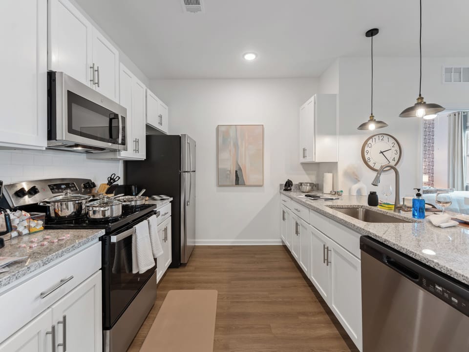 Modern kitchen with granite counters, stainless appliances & water views