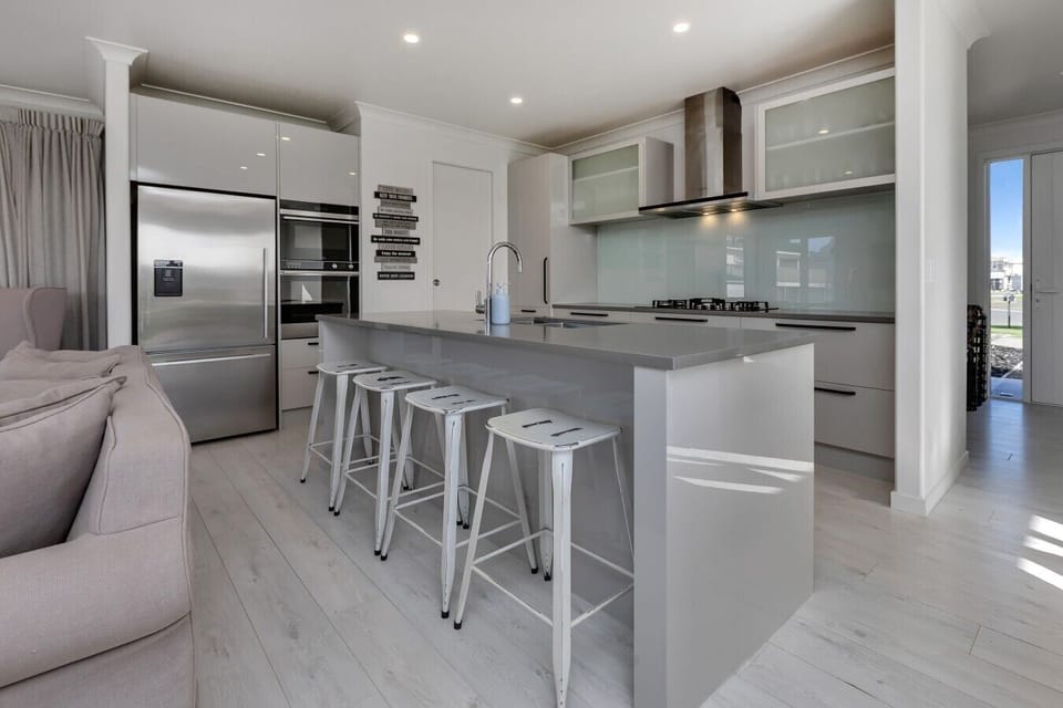Fully equipped kitchen featuring a large central island and bar stools.