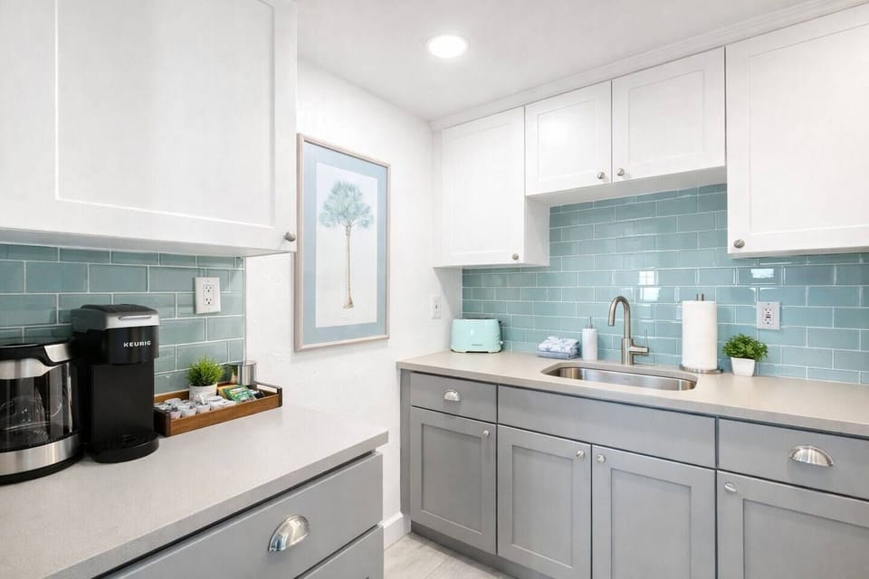 Fully stocked kitchenette with coffee station, clean countertops, and coastal design—perfect for easy mornings and light cooking.