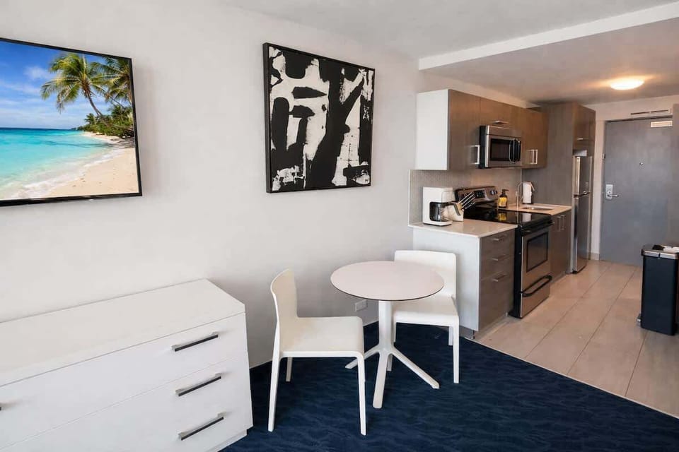 Studio dining and kitchenette area featuring a small dining table, modern décor, and a fully equipped kitchen for convenient meals.