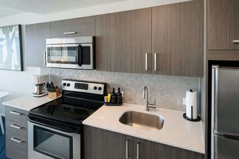 Clean and modern kitchenette featuring sleek cabinetry, stainless steel appliances, and everything guests need to cook or prepare quick meals.