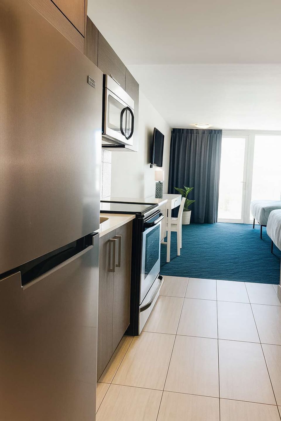 Modern kitchenette with stainless steel appliances, sleek cabinets, and bright natural light—perfect for preparing meals during your stay.