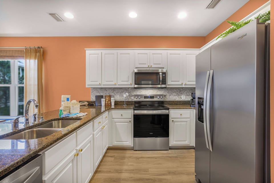 Bright modern kitchen with granite counters and stainless steel appliances