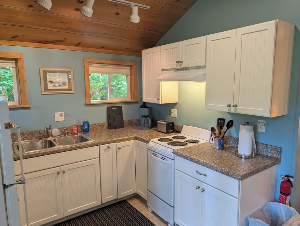 KITCHEN: The accommodating kitchen suited with a fridge, an oven, a toaster, a coffeemaker, and other kitchen essentials