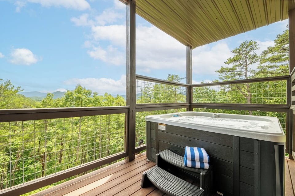 Soak beneath a covered terrace with sweeping mountain vistas stretching across lush forest. The deck offers a serene retreat where you can unwind in comfort surrounded by nature's beauty.