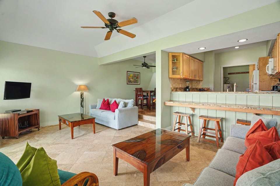 Relax in your open-concept living space with cooling ceiling fans, comfortable seating, and a fully-equipped kitchen with breakfast bar—perfect for unwinding after a day of adventure.
