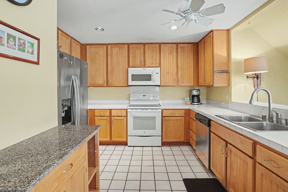 A well-equipped kitchen awaits with modern appliances, warm wood cabinetry, and ample counter space for preparing your favorite meals during your stay.