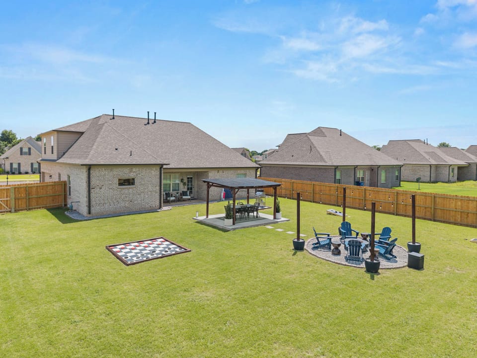 The fully fenced backyard is designed for connection, featuring outdoor dining, games, string lights and a gas fir pit lounge.
