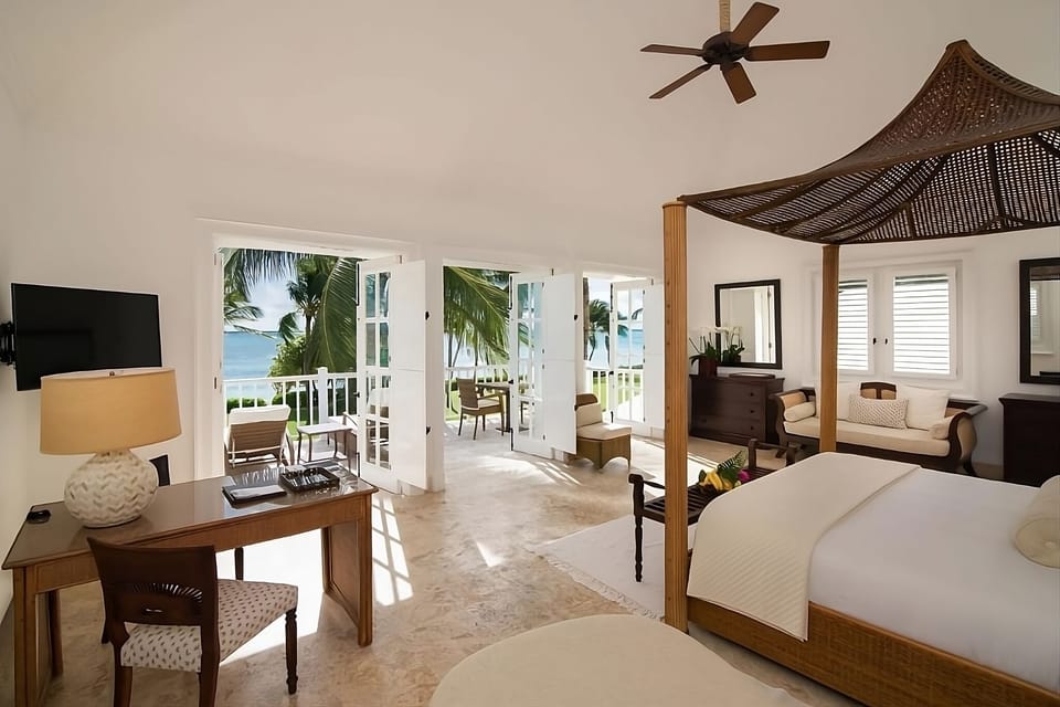 Wake to ocean breezes in a sunlit canopy-bed retreat.