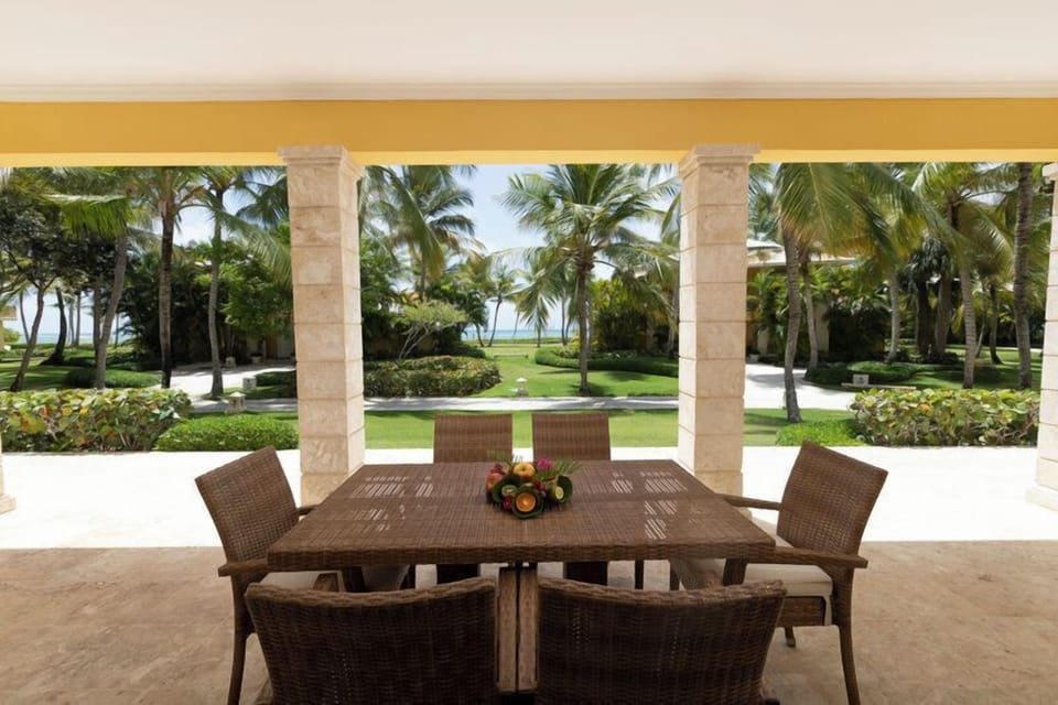 Savor long alfresco meals overlooking palms, lawn, and ocean views