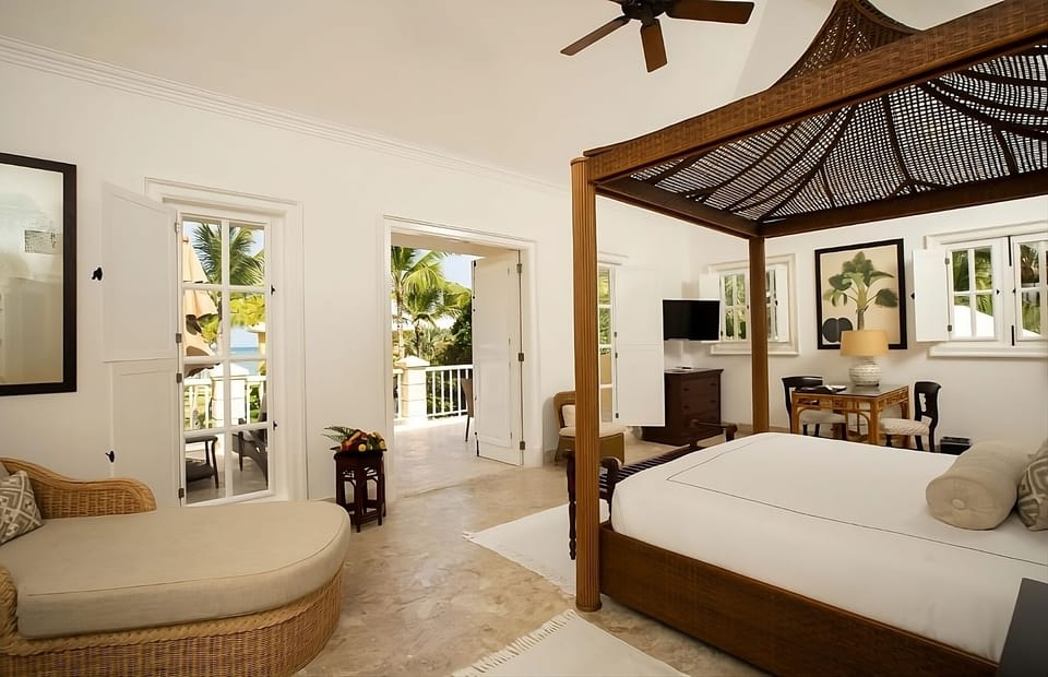 Indulge in a romantic canopy bed with balcony sunshine.