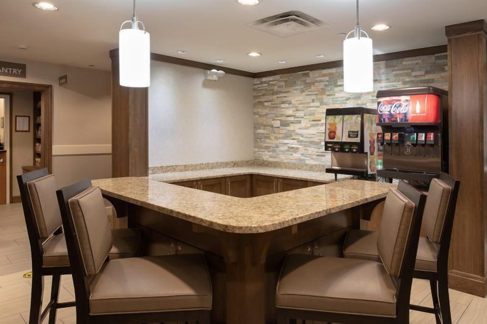 On-site grab-and-go pantry with seating and beverage station.