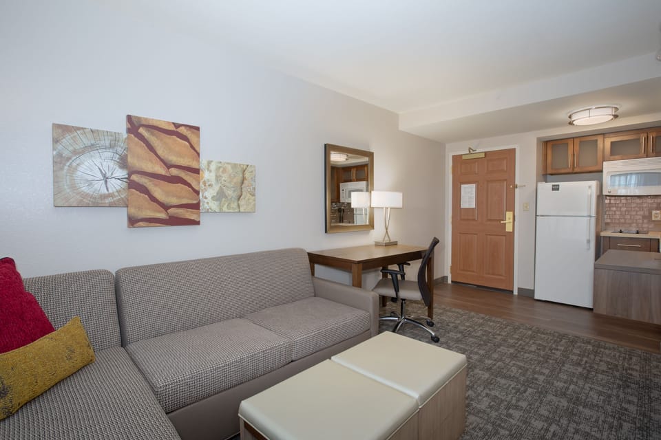 Spacious living area with stylish furniture and desk workspace.