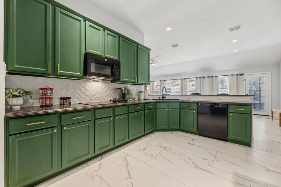 Chef-Ready – A beautifully designed kitchen featuring floor-to-ceiling green cabinets, full appliances, and generous counter space for effortless group cooking.