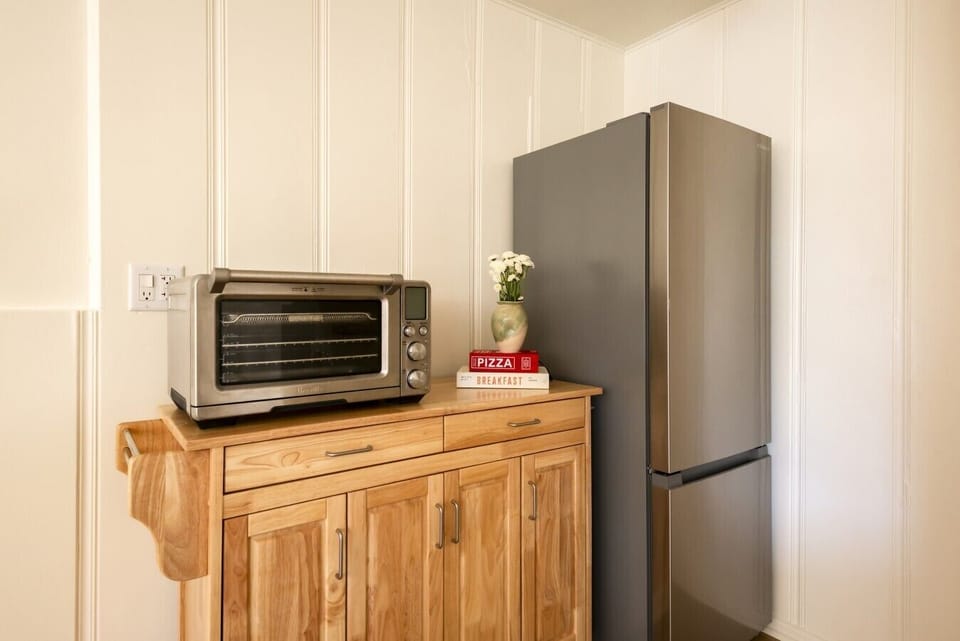 Compact kitchen setup with toaster oven and full-size refrigerator.