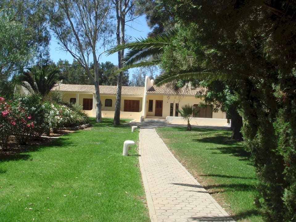 Front yard | View from the  entrance gate:
A surprisingly large front garden welcomes you to the villa, with the living-room porch on the right and bedroom verandas on the left