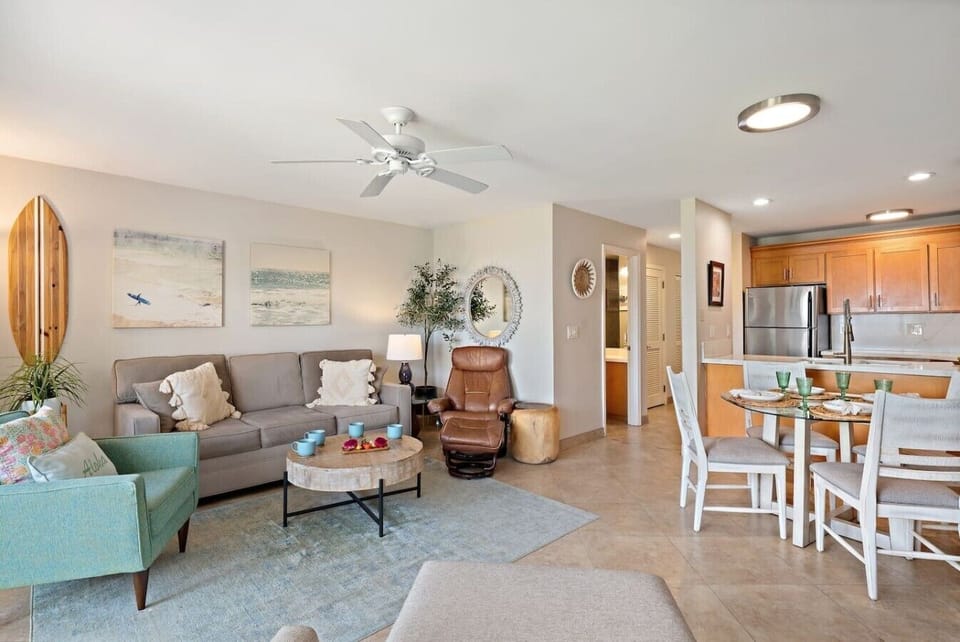 Sunlit Island Retreat ☀️  Relax in a bright, AC-cooled living area with a flat-screen TV and floor-to-ceiling windows. Step out onto the private balcony for lush tropical views just outside your door.