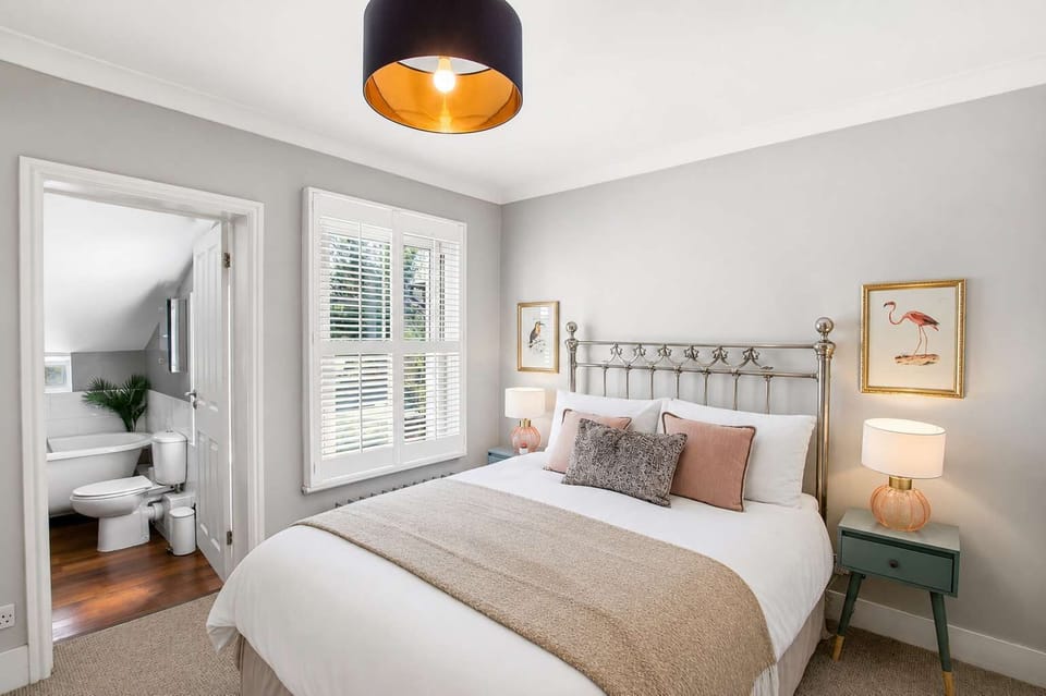 Bedroom Retreat: Plush double bed with warm lighting and serene neutral tones for sweet dreams!