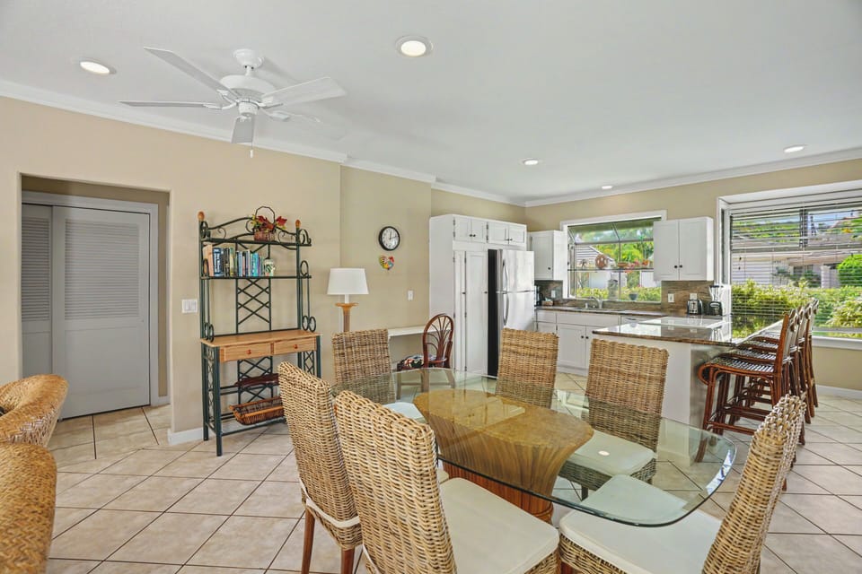 Gather around the glass-topped table in your bright, airy dining space, where wicker chairs and coastal charm set the scene for memorable meals together.