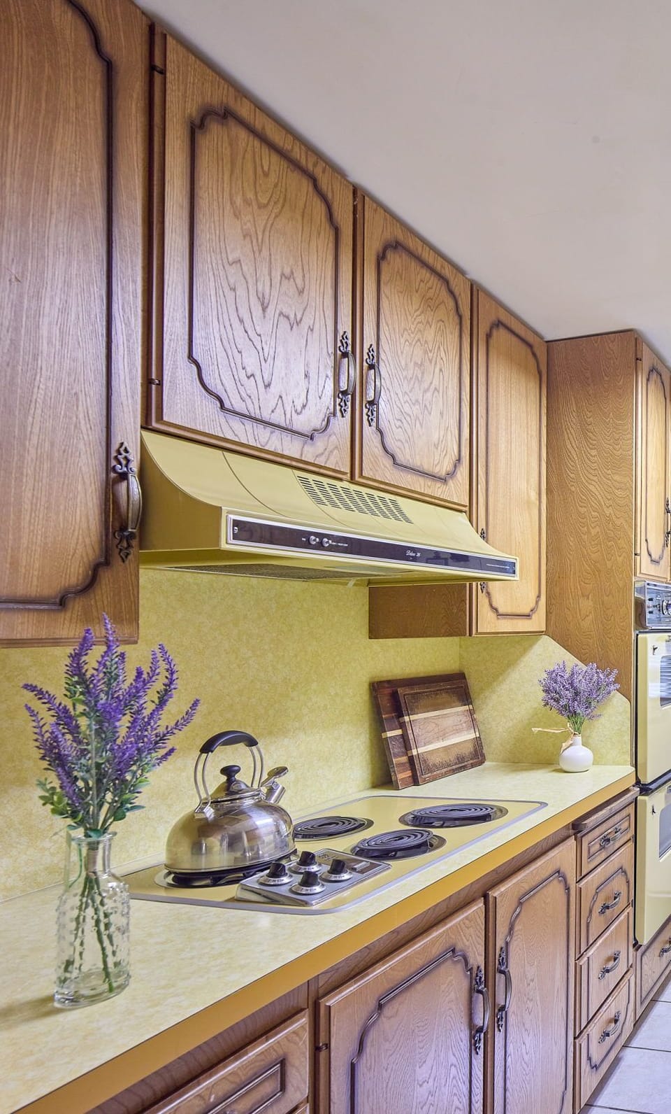 Kettle, burners, and small appliances on the kitchen counter under warm overhead lighting