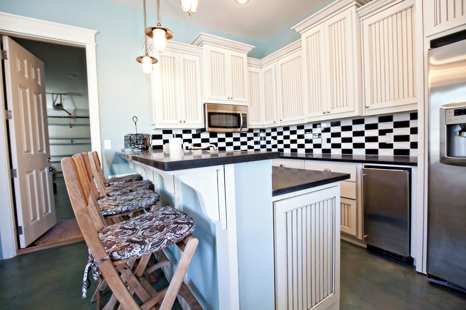 Cook your favorite meals in this charming kitchen with bright white cabinetry, modern stainless appliances, and a breakfast bar for casual dining.