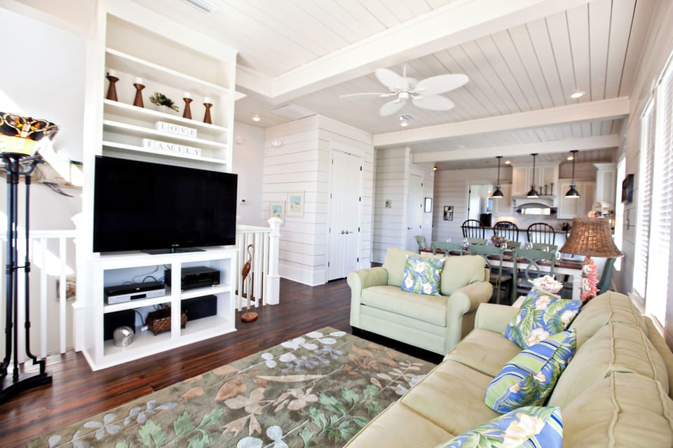 Unwind in this bright, coastal-inspired living area with comfortable seating and charming shiplap walls welcoming you home.