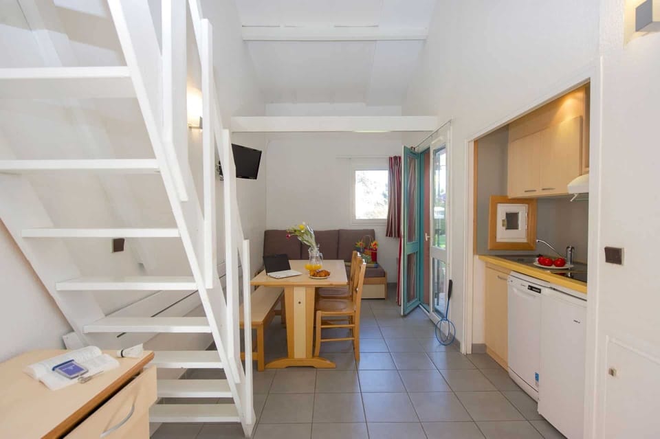 The living space with sofa bed and staircase — one of the Hameau's two-storey apartments on the estate.
