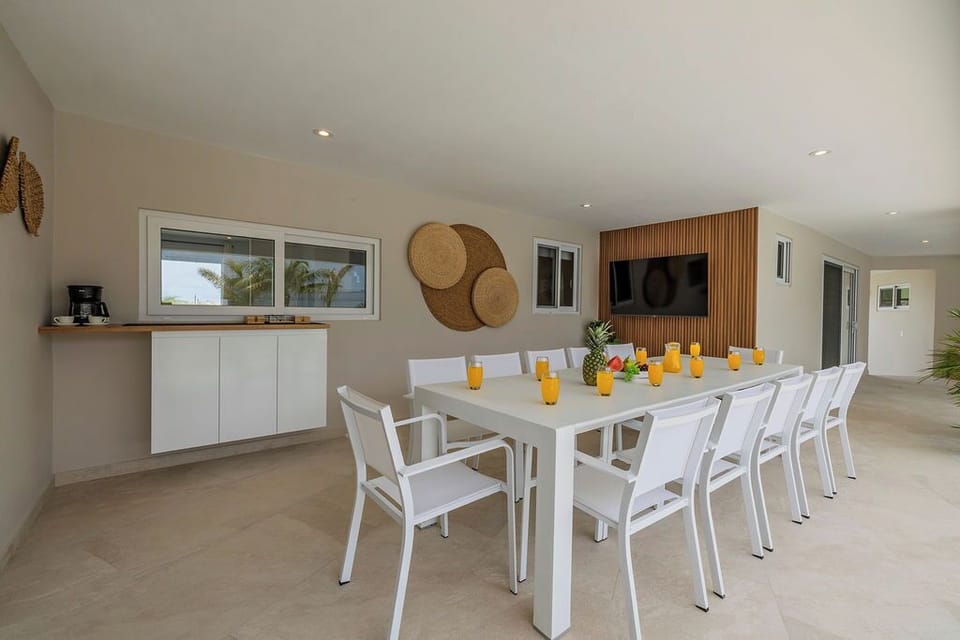 Complete with an outdoor dining area and a sleek, contemporary villa backdrop.