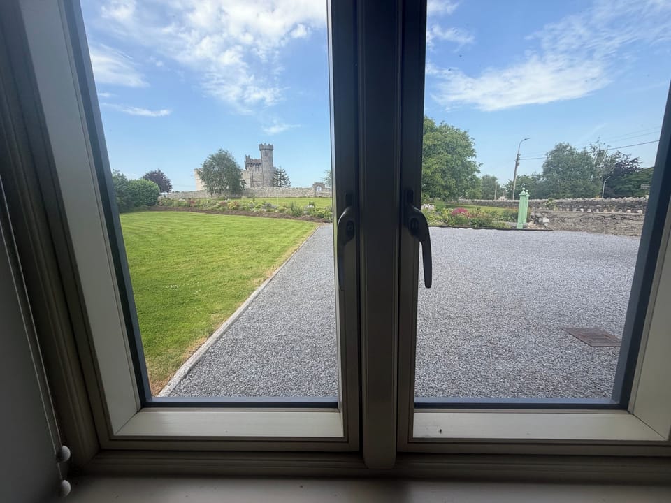 The views from the ground floor bedroom windows - across the lawn and parking area to Carrigeen Castle avenue gardens.