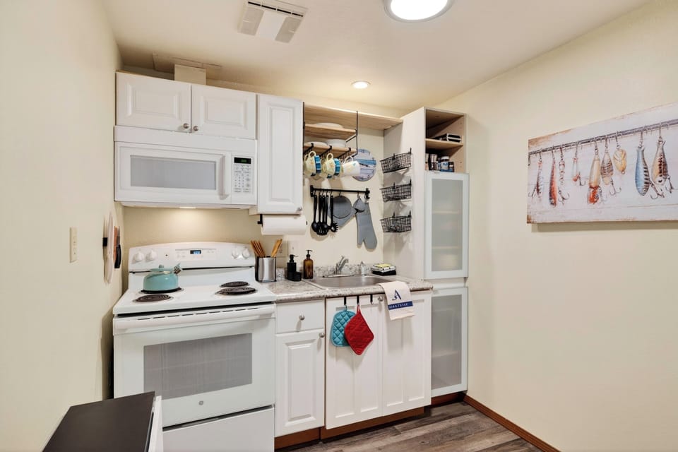 Compact kitchen stocked for simple meals during your Whidbey Island stay.