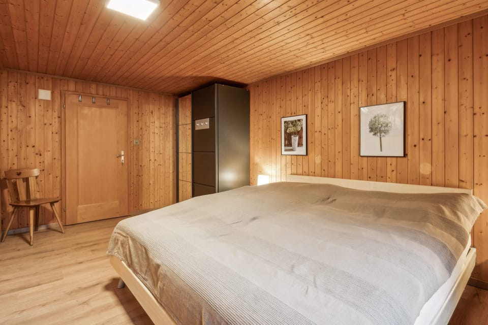 Master bedroom featuring warm wooden interiors and hotel-quality bedding.
