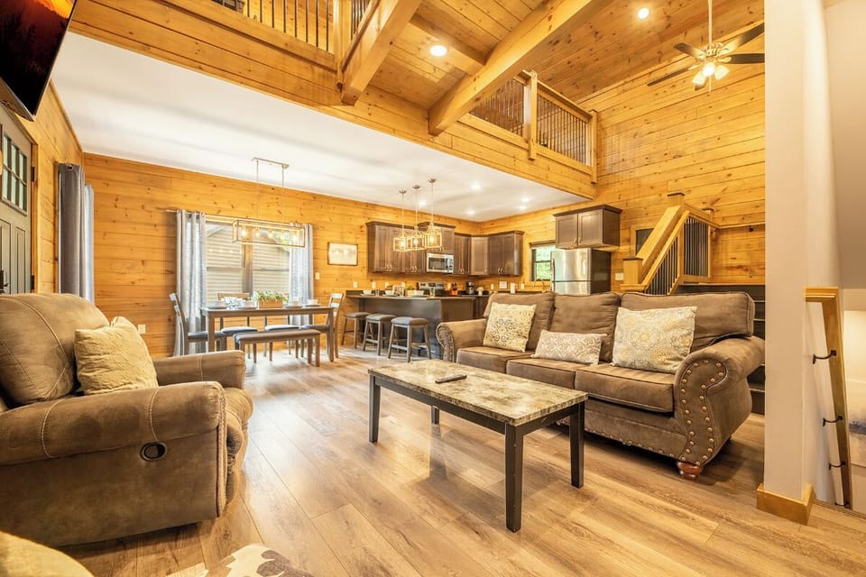 Settle into the warmth of soaring wood-beam ceilings and rustic charm—your open-concept retreat offers plush seating, a fully equipped kitchen, and cozy loft space above.