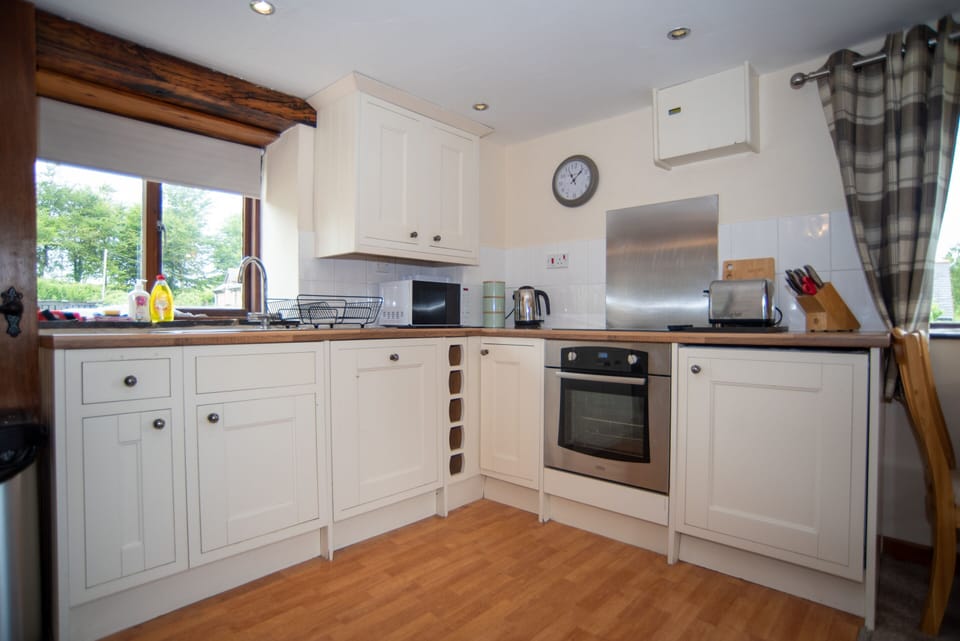 Prepare family meals with ease in the well-equipped kitchen featuring an oven, hob, microwave and all the essentials for a self-catering stay.