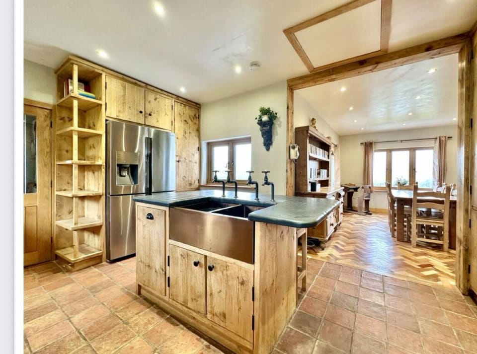 american fridge freezer with ice machine. neff oven and induction hob. air fyer, microwave, kettle, toaster, double belfast copper sink, and an aga when it is winter