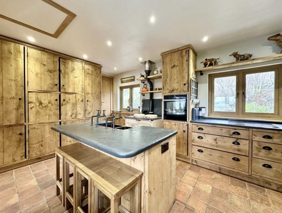 american fridge freezer with ice machine. neff oven and induction hob. air fyer, microwave, kettle, toaster, double belfast copper sink, and an aga when it is winter