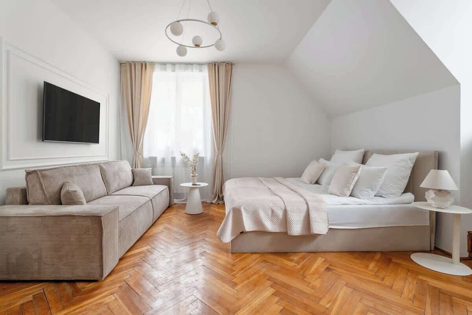 Salon z częścią sypialnianą został wyposażony w wygodne łóżko małżeńskie oraz rozkładaną sofę. Naprzeciwko znajduje się telewizor z kanałami TV, idealny na wieczorny relaks. Przeszklona szafa oferuje dużo miejsca do przechowywania.