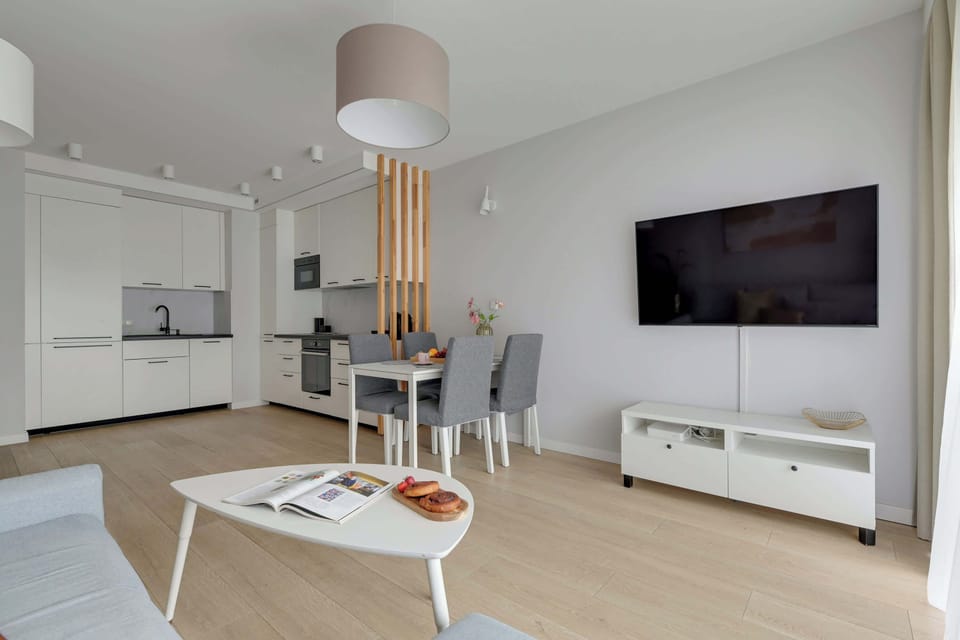 Chlebova 2.06 to jasny i funkcjonalny apartament dla 5 osób, w tym maksymalnie 4 dorosłych. Oferuje sypialnię, salon z aneksem kuchennym i jadalnią, łazienkę z prysznicem i pralką oraz balkon z widokiem na rzekę.