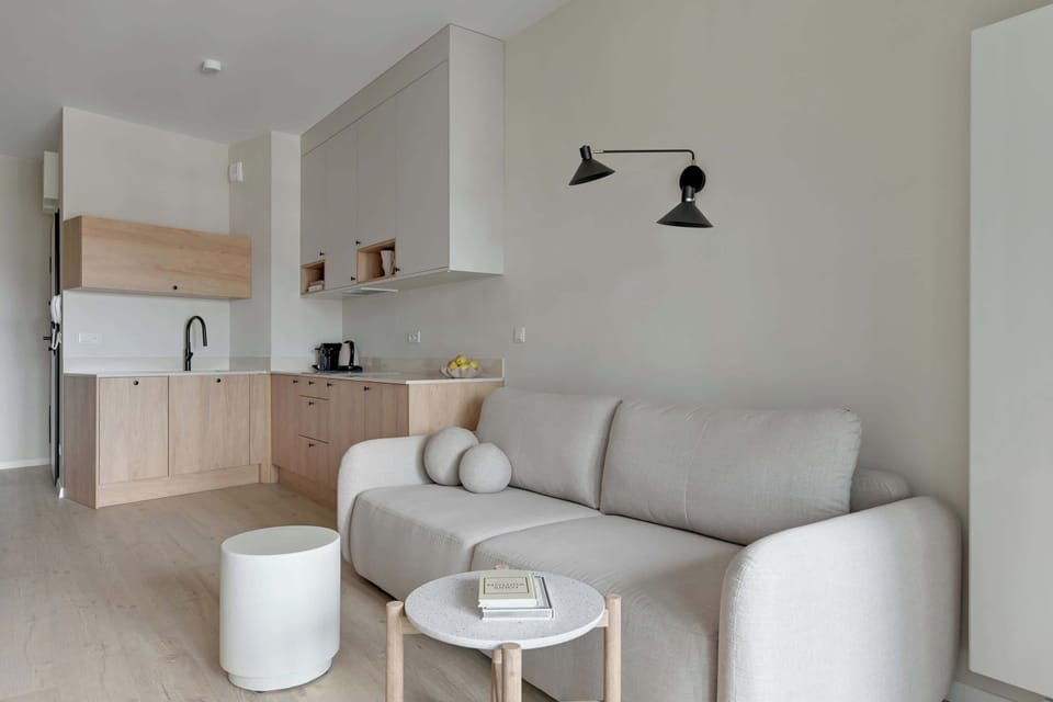 Główną część apartamentu stanowi otwarta przestrzeń łącząca salon i sypialnię. Znajduje się tu wygodne łóżko małżeńskie, sofa oraz telewizor z funkcją Smart TV i kanałami kablowymi.