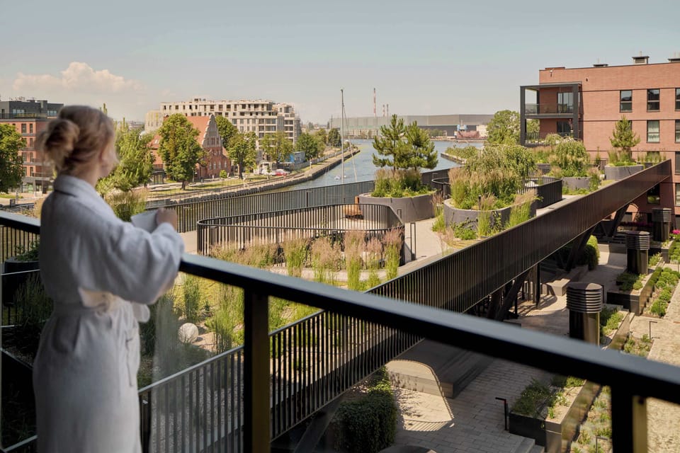 Apartament posiada balkon z meblami ogrodowymi, który stanowi dodatkową przestrzeń do wypoczynku. To idealne miejsce na poranną kawę, spokojny wieczór lub chwilę relaksu na świeżym powietrzu.
